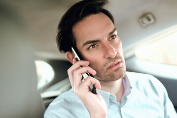 Businessman on phone call inside a car during a busy afternoon in the city