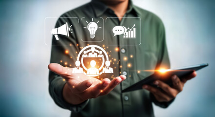 Businessman holding a tablet displaying a digital interface with icons representing business strategy, marketing, communication, and data analysis, symbolizing modern corporate management and teamwork