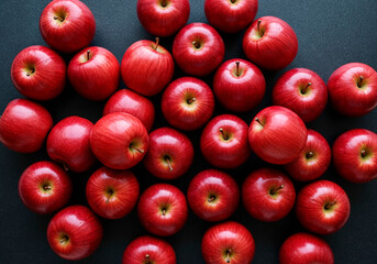 Vibrant top-down view of a cluster of fresh red apples on a dark background, highlighting healthy fruit abundance and natural beauty.