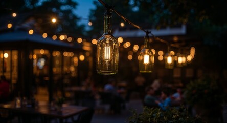 Obraz premium Close up of lightbulb inside a wine bottle hanging outdoors at a restaurant at night with people sitting