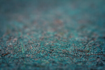 Extreme closeup of turquoise handmade paper with shallow depth of field.