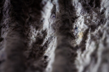 Extreme close up of old gray handmade paper clay with a structure and rough texture. Paper recycling. Selective soft focus, shallow depth of field.