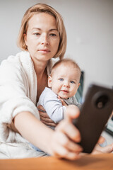 Authentic shot of neo mother and her newborn baby making a video call to father or relatives with...