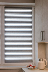 Fototapeta premium Modern kitchen window with double roller zebra blinds, allowing adjustable daylight while maintaining privacy. Stylish design fits seamlessly into contemporary interior spaces.