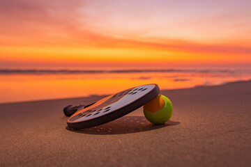 Scenic coastal evening with beach tennis gear illuminated by warm sunlight. Great inspiration for nature sport and summer holidays.