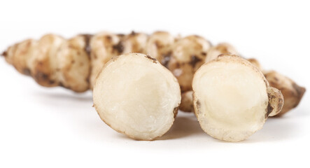 Freshly cut ground silkworms alongside whole pagoda vegetables on a white background for a healthy...