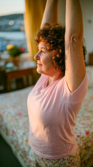 A woman with curly hair stretches her arms overhead in a softly lit bedroom. Floral bedding and a window with a scenic view add warmth to the space.