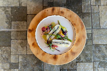 Freshly prepared fish dish served with vibrant vegetables and herbs in cozy dining setting