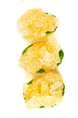 Handmade large yellow icing sugar cane cubes arranged on green leaves for sweet presentation