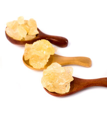 Handmade ancient yellow rock sugar displayed on wooden spoons in natural light
