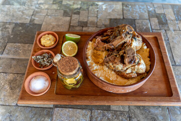 Delicious traditional dish with seasoned meat, creamy polenta, and fresh garnishes served in a rustic setting