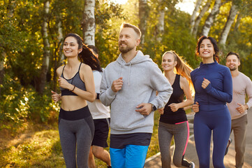 Group of smiling Caucasian men and women, friends or training class participants in athletic wear,...