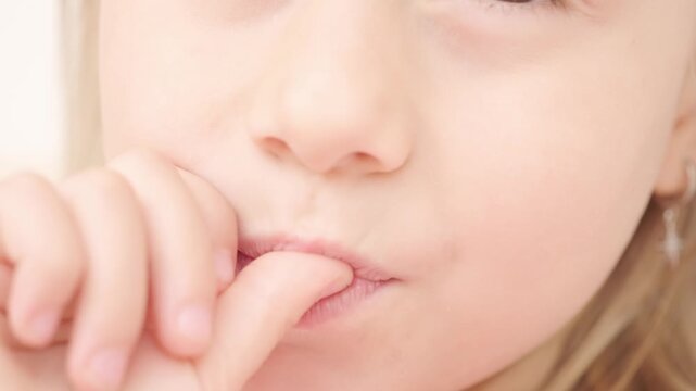 Little girl wiggling loose baby tooth with finger, Child focused on wobbly tooth, exploring changes in growing body with curiosity and wonder, childhood moment, dental milestone,