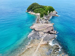 Aerial drone view of Senjojiki on Naru Island, Goto Islands, Nagasaki, Japan – coastal rock terraces, turquoise waters, and lush green landscape under clear summer sky.