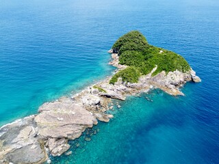 Aerial drone view of Senjojiki on Naru Island, Goto Islands, Nagasaki, Japan – coastal rock terraces, turquoise waters, and lush green landscape under clear summer sky.