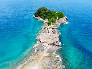 Aerial drone view of Senjojiki on Naru Island, Goto Islands, Nagasaki, Japan – coastal rock terraces, turquoise waters, and lush green landscape under clear summer sky.