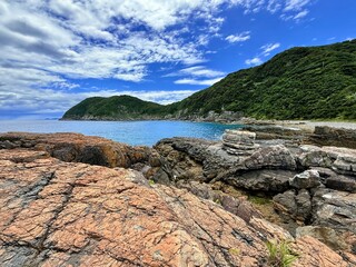 Aerial drone view of Senjojiki on Naru Island, Goto Islands, Nagasaki, Japan – coastal rock terraces, turquoise waters, and lush green landscape under clear summer sky.