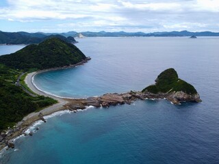 Aerial drone view of Senjojiki on Naru Island, Goto Islands, Nagasaki, Japan – coastal rock terraces, turquoise waters, and lush green landscape under clear summer sky.