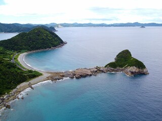 Aerial drone view of Senjojiki on Naru Island, Goto Islands, Nagasaki, Japan – coastal rock terraces, turquoise waters, and lush green landscape under clear summer sky.