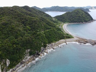 Aerial drone view of Senjojiki on Naru Island, Goto Islands, Nagasaki, Japan – coastal rock terraces, turquoise waters, and lush green landscape under clear summer sky.