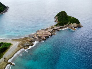 Aerial drone view of Senjojiki on Naru Island, Goto Islands, Nagasaki, Japan – coastal rock terraces, turquoise waters, and lush green landscape under clear summer sky.