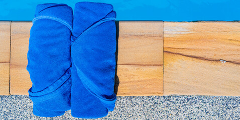 A blue towel is placed by the poolside.