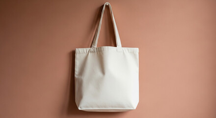 White canvas tote bag hangs on terracotta wall, showcasing blank surface for branding or design, minimalist style, ideal for mockup