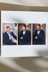 page of an open photo book with wedding photos on a white table