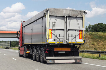 Cargo truck on highway road. Rear view of large freight vehicle. Transportation of goods in...