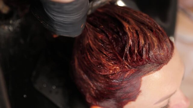 Close-up of a stylist doing hair coloring used in a salon setting. Vertical video