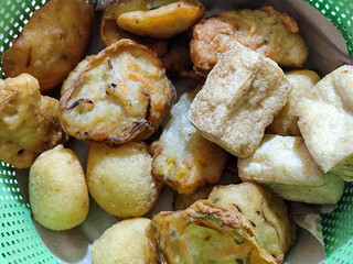 Gorengan, traditional Indonesian street food consisting of brontak tofu, fried banana, bakwan, jemblem, etc. Goes well with green chilies.