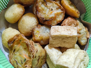 Gorengan, traditional Indonesian street food consisting of brontak tofu, fried banana, bakwan, jemblem, etc. Goes well with green chilies.