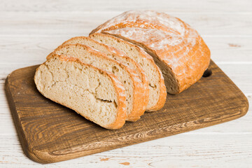 Assortment of freshly sliced baked bread with napkin on rustic table top view. Healthy unleavened...