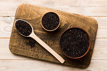quinoa seeds in bowl and spoon on colored background. Healthy kinwa in small bowl. Healthy superfood