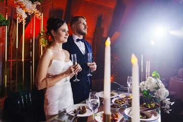 The bride and groom listen to congratulations and toasts from guests