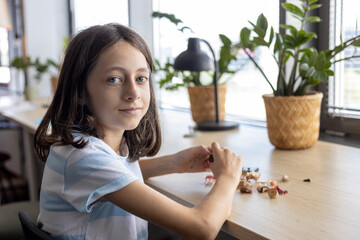 Young student assembling parts of educational project, learning through creative activity and...