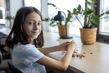 Young student assembling parts of educational project, learning through creative activity and...