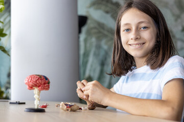 Young student assembling parts of educational project, learning through creative activity and...