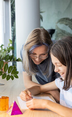 Two schoolgirls aged 11 and 13 working together on a STEM geometry project, exploring shapes and spatial concepts through hands-on learning and collaborative classroom activity.