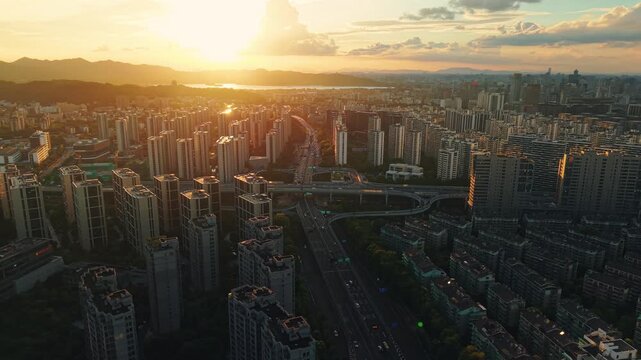Aerial view of a residential buildings alongside a multilane highway interchange filled with moving vehicles