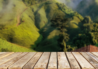 Wooden table top on blur mountain and grass field.Fresh and Relax concept.For montage product display or design key visual layout.View of copy space.