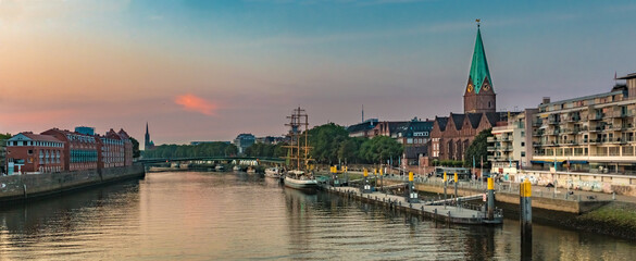 Large panorama of the Weser river with the famous Schlachte embankment on the east bank in Bremen during sunset.