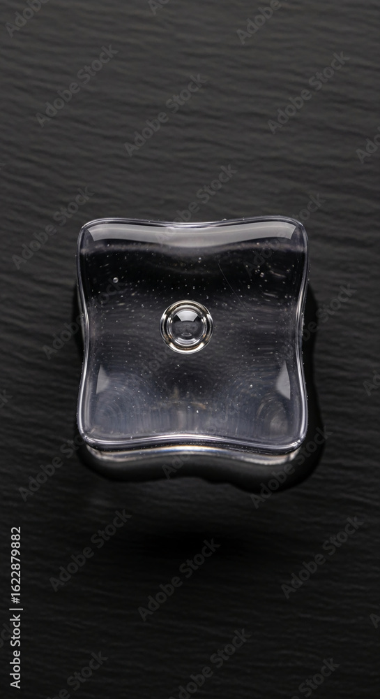 Poster transparent gel cube on dark surface, showcasing a clean and simple design, ideal for product displa
