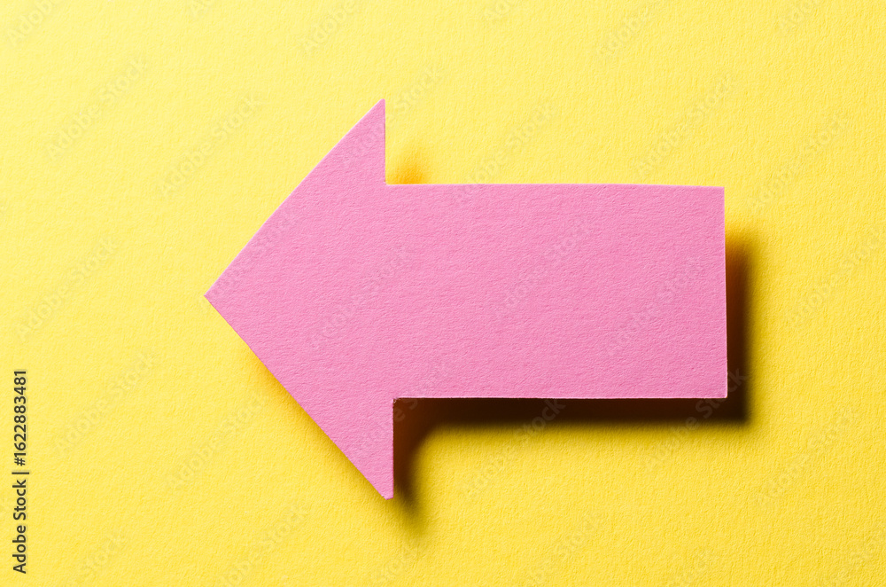 Aufkleber pink cut out blank paper cardboard arrow direction sign with copy space for text on yellow backgroun