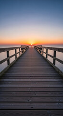 Obraz premium Wooden pier extending to sunrise over calm water, showcasing tranquil serenity and peaceful journey concept
