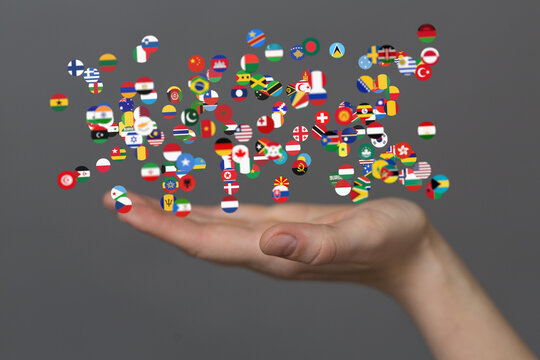 Image of many flags floating above an open hand, representing global unity and connection.