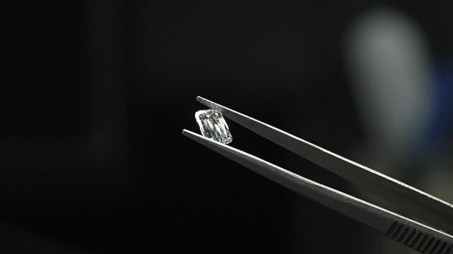 diamond with tweezers closeup micro view in diamond manufactiring unit 