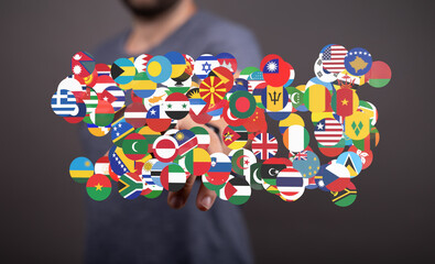 Image of a person interacting with a digital display of various world flags, representing global...