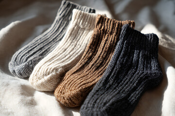 A cozy collection of knitted wool socks in neutral tones, showcasing texture and warmth on fabric.