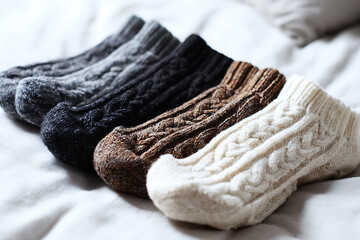 A cozy arrangement of knitted socks in varying shades, showcasing warmth and comfort on a soft, inviting surface.